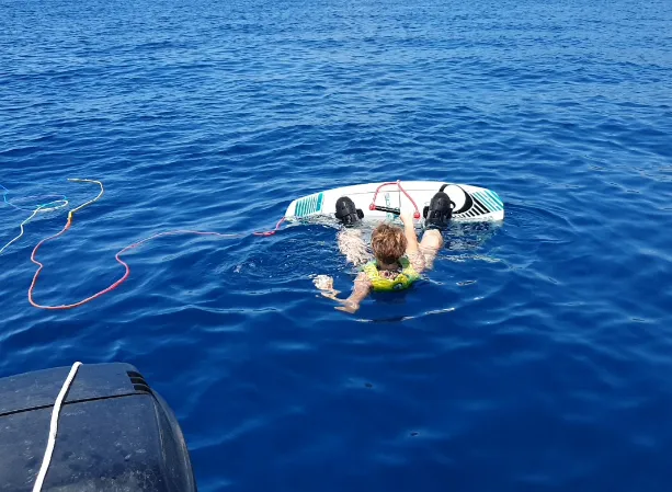 Ein Jugendlicher mit seinem Wakeboard im Wasser